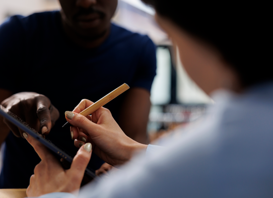 Close-up of an employee using a stylus on a tablet for a digital check-in.